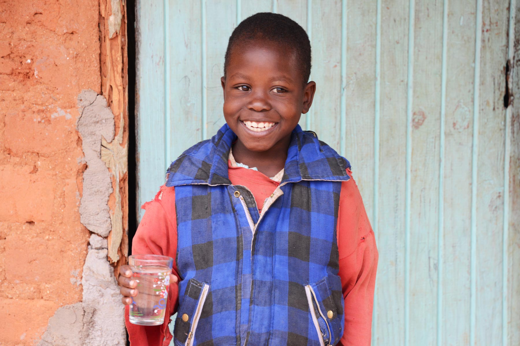 Clean-water-changes-lives-PS1800 child holding a glass of clean water